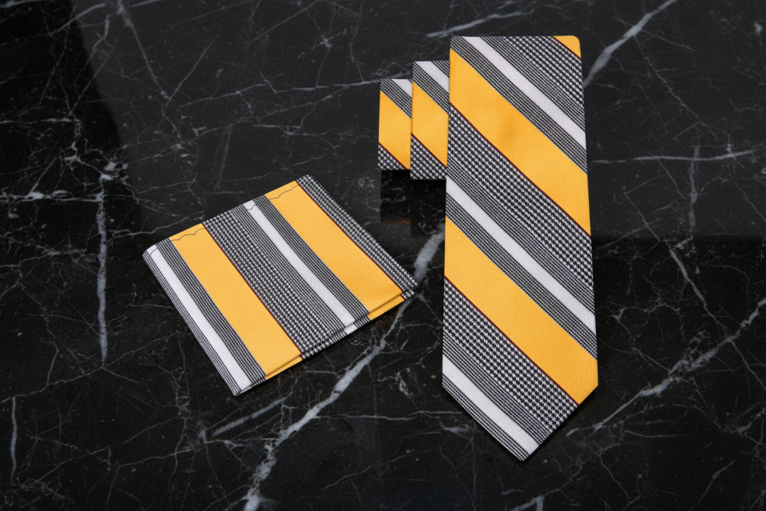 Set of yellow and gray striped ties on a grey background