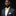 Man wearing a gray suit with a yellow bow tie on a black background