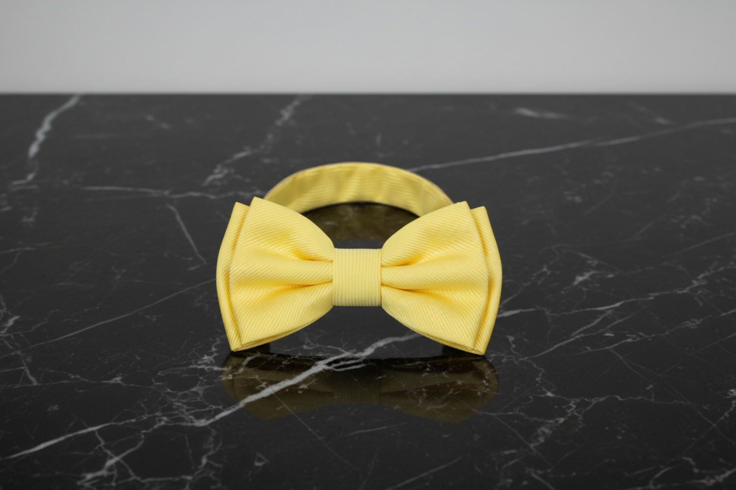 A solid yellow pre tied bow tie