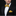 Man wearing a black tuxedo with a gold bow tie and pocket square on a black background