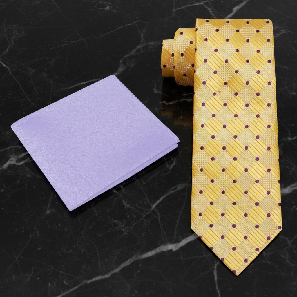 Yellow patterned tie and purple pocket square on a black marble surface