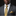 Man wearing a gray suit with a yellow plaid tie and pocket square against a black background