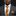 Man wearing a gray suit with a yellow patterned tie and pocket square on a black background