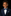 Young boy in a navy suit with a blue bow tie and pocket square on a black background