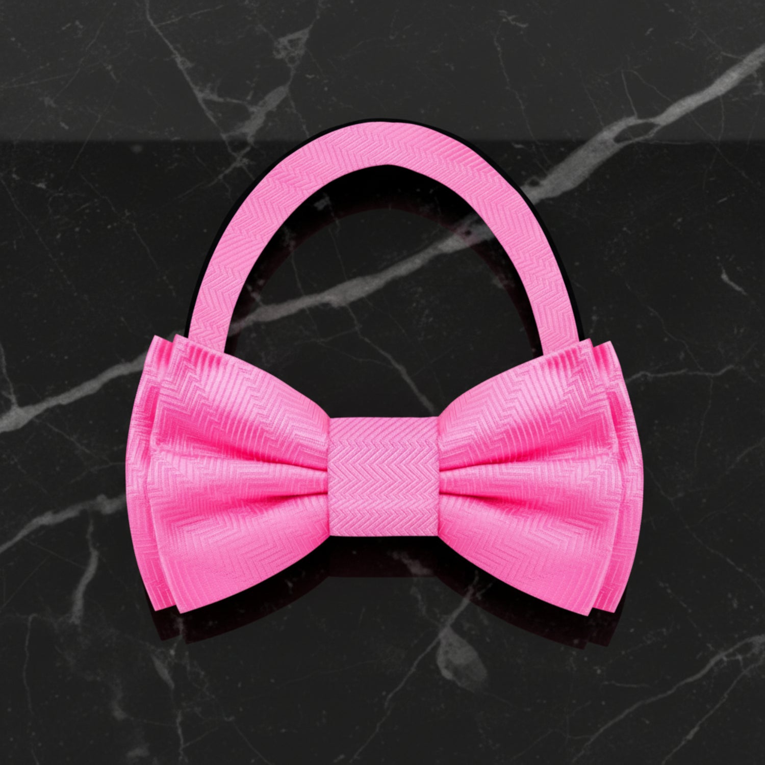 pink pre tied bow tie on black marble