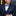 Man wearing a navy suit with a blue bow tie and pocket square.