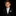 Young boy in a black suit with a white shirt and tie on a black background
