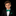 Young boy in a black suit with a green bow tie on a black background