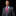 Man wearing a gray suit with a pink tie and pocket square on a black background