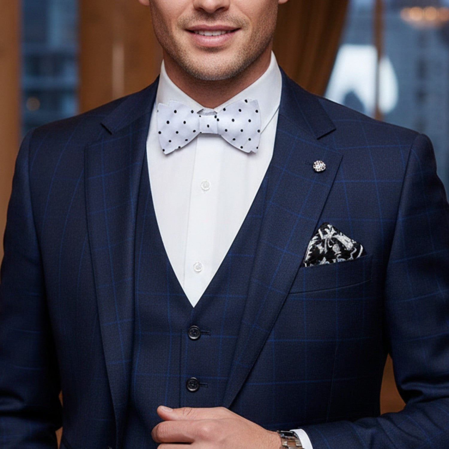 Man wearing a navy checkered suit with a white shirt and polka dot bow tie.