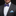 Man wearing a gray suit with a blue striped bow tie and pocket square on a black background