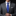 Man wearing a gray suit with blue tie and white square against a black background