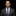 Man wearing a dark suit with a patterned tie against a black background