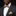 Man wearing a gray suit with a yellow and blue bow tie and pocket square on a black background