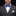 Man wearing a gray suit with a blue floral bow tie and white square on a black background