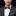 Man wearing a gray suit with a red checkered bow tie on a black background