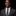 Man wearing a dark suit and green-striped tie against a black background