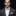 Man wearing a gray suit with a blue bow tie and pocket square on a black background