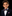 Young boy in a suit with a colorful bow tie and pocket square on a black background