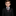 Young boy in a formal black suit with a red tie and pocket square on a black background