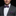 Man wearing a gray suit with a colorful bow tie and pocket square on a black background