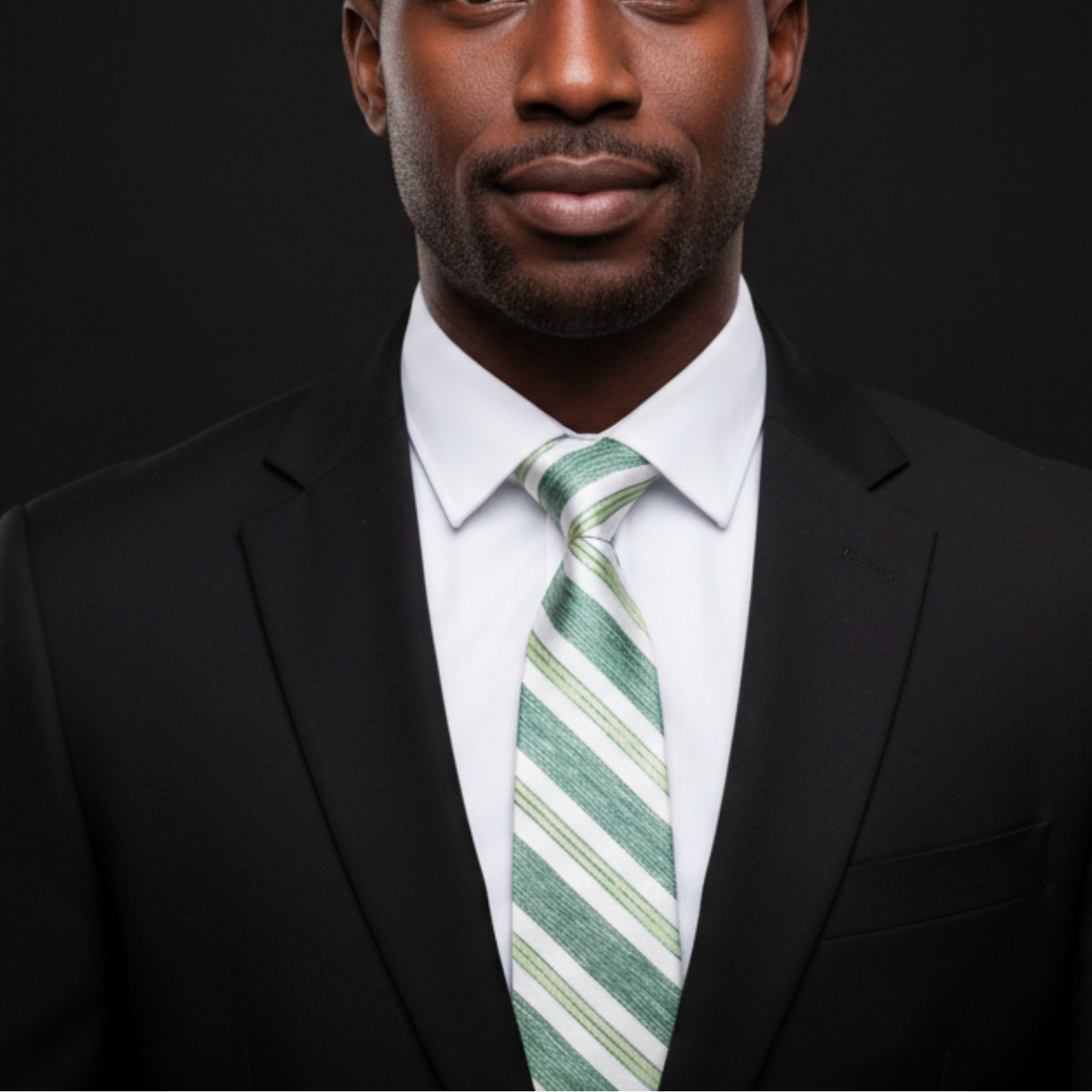 Man wearing a black suit with a white shirt and green striped tie on a dark background