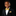 Young boy in a black suit with a yellow bow tie and pocket square on a black background
