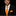 A man wearing a black suit jacket, white dress shirt, and a bright orange and white checkered tie with a matching pocket square, set against a solid black background.
