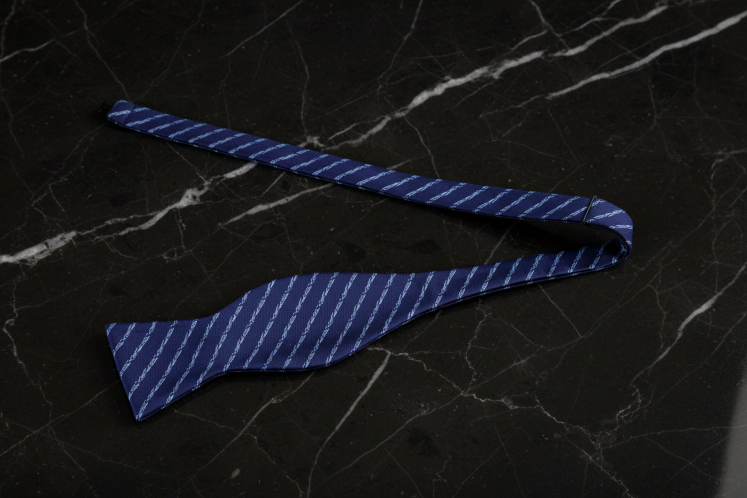 A Dark Blue, Light Blue Stripe Pattern Self-Tie Bow Tie Untied