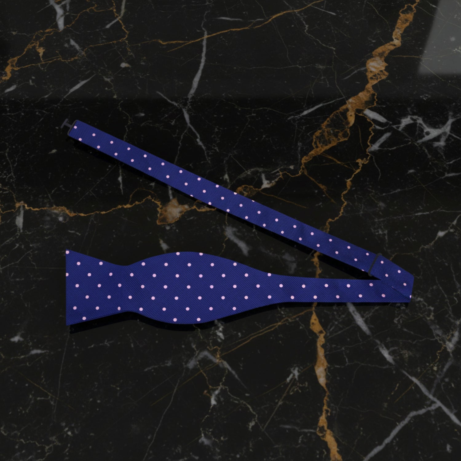 A blue and pink polka dot bow tie untied