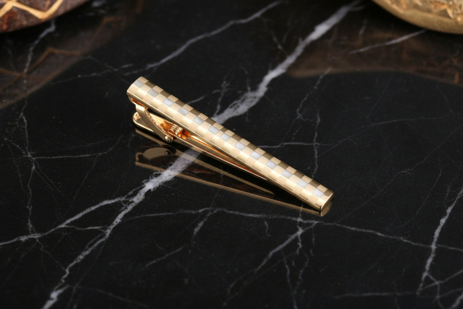 A Gold Colored Checkered Pattern Tie Bar