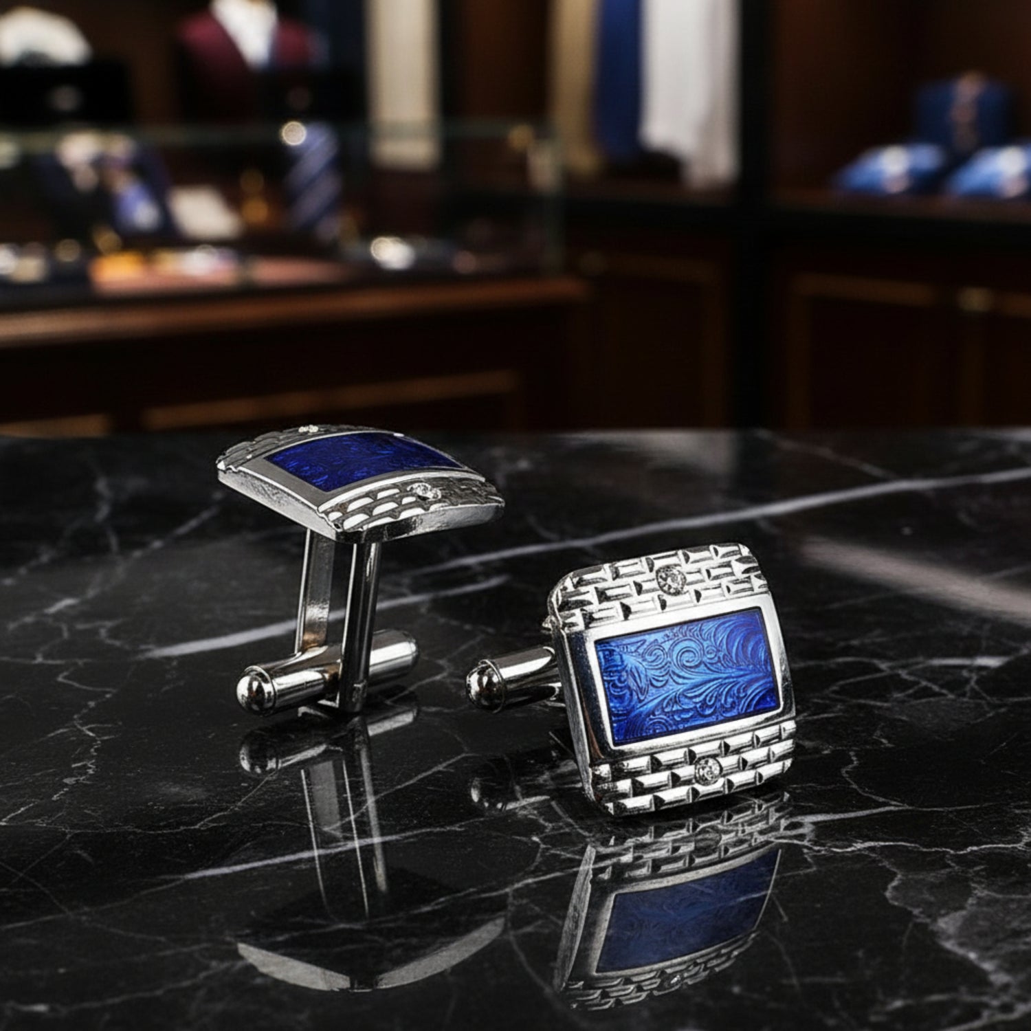 A chrome and blue colored rectangle shaped with checkerboard and waves detail pair of cuff-links