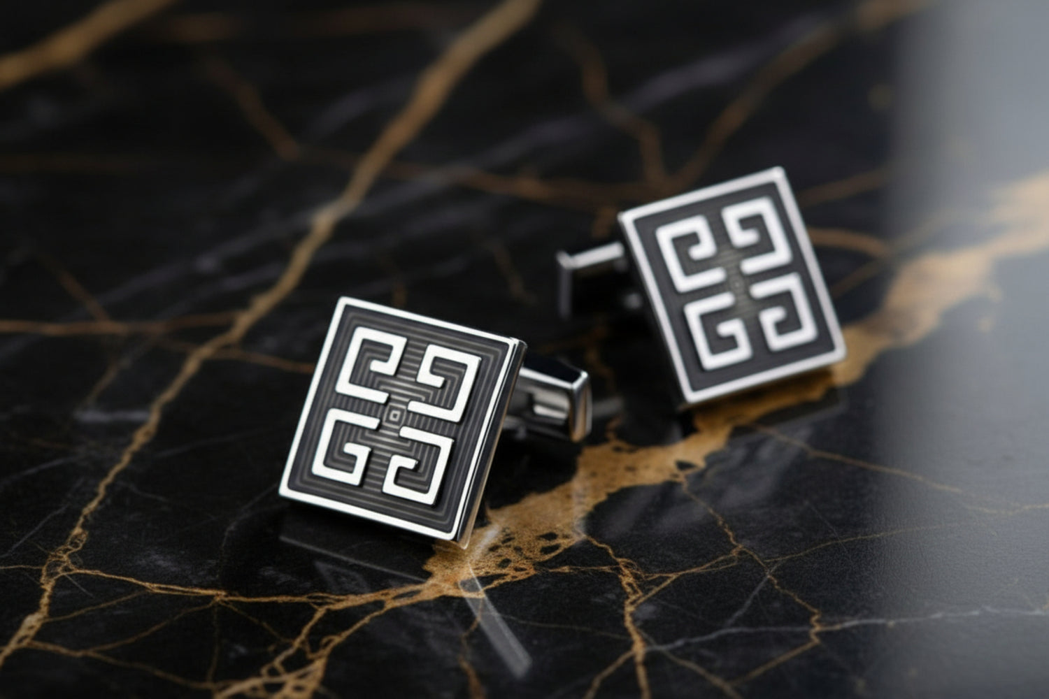 A Black, Chrome Colored Square Shape With Intricate Design Cuff-links.