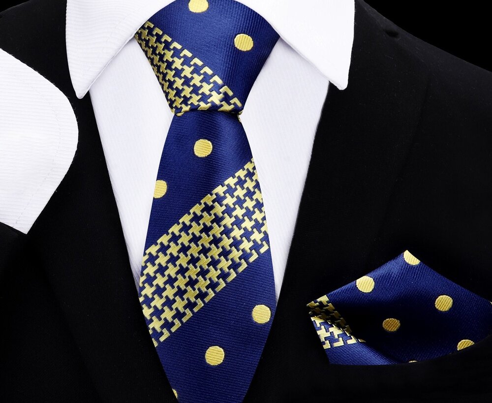 A set of kids' formal wear including a dark blue necktie with gold polka dots and hounds-tooth pattern, and a matching pocket square, displayed on a mannequin dressed in a black suit and white shirt.
