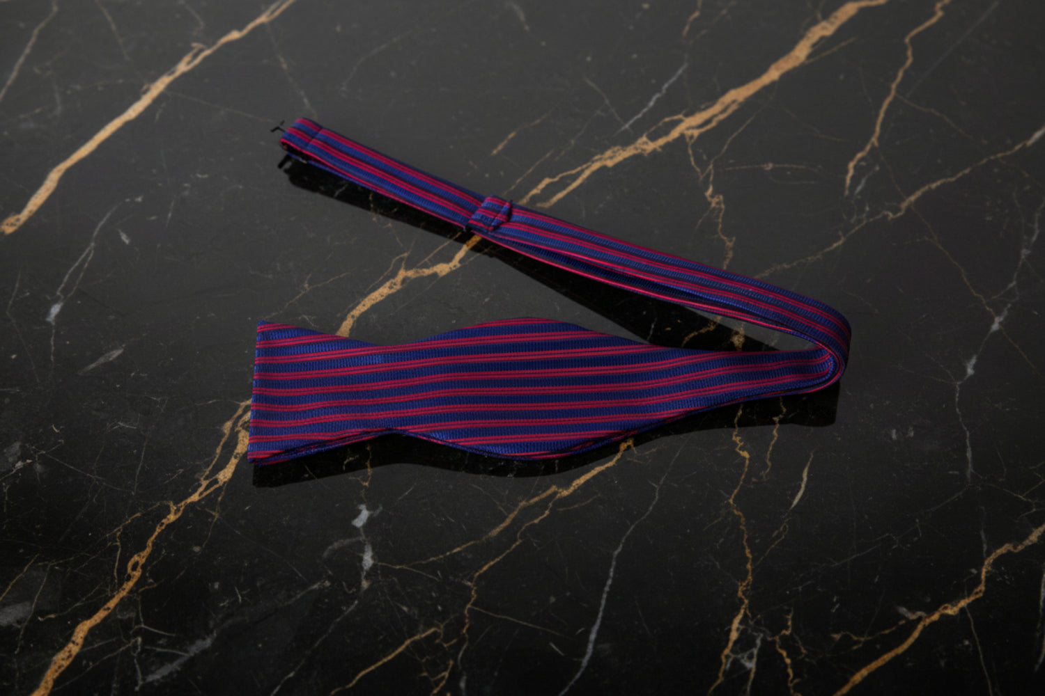 A Red, Blue Stripe Pattern Self Tie Bow Tie Untied