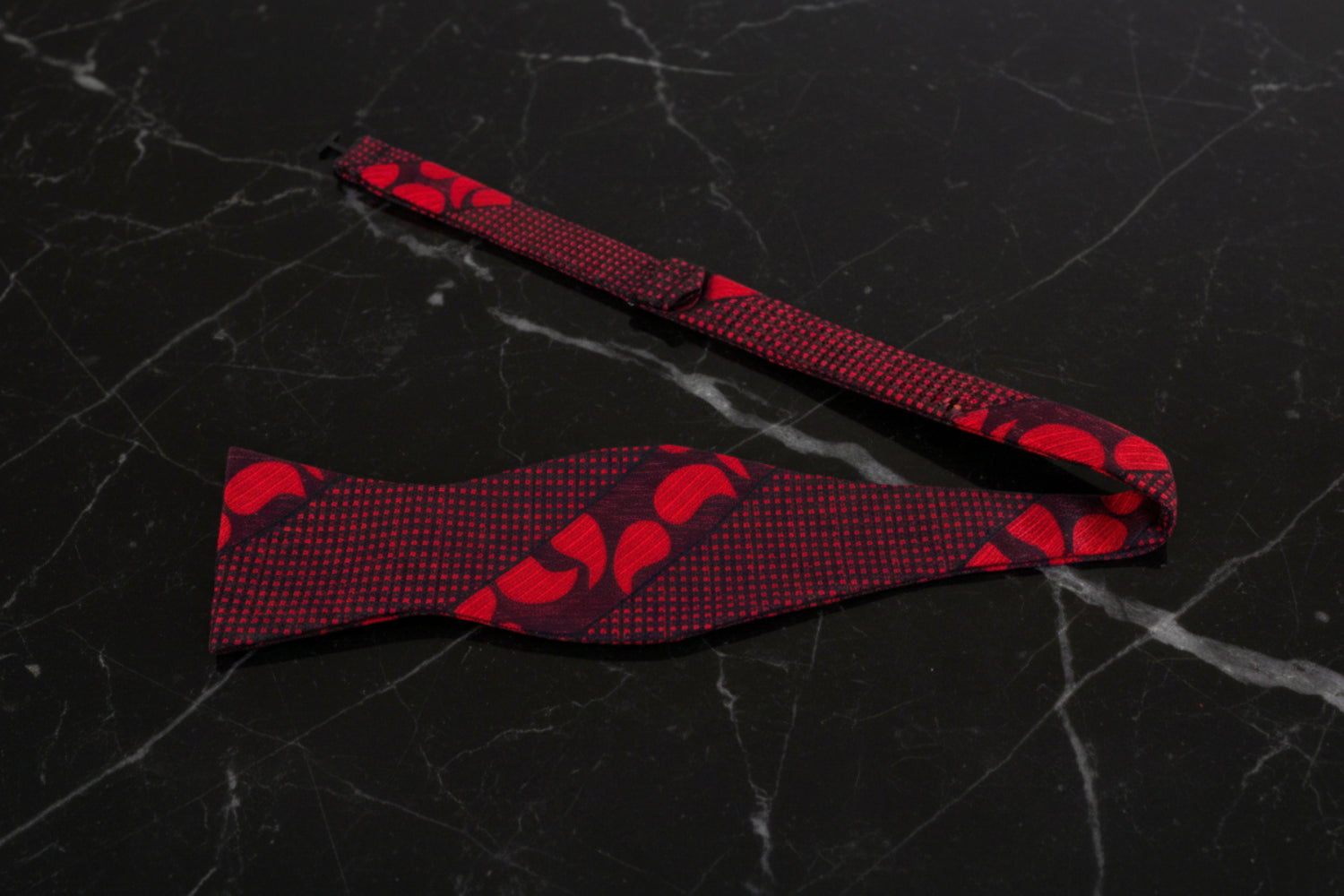A Red, Black Paisley Pattern Self Tie Bow Tie Untied View
