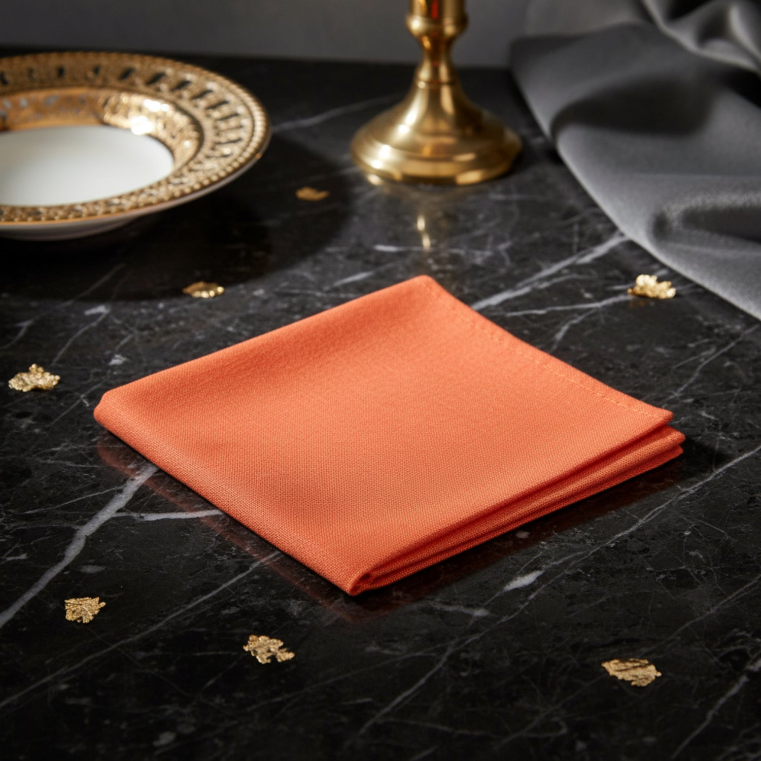 A solid orange linen pocket square placed on a stone surface.