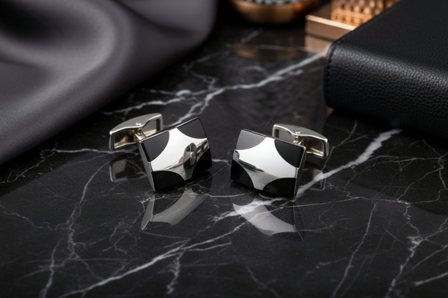 A Black, Chrome Colored X Shaped Cuff-links
