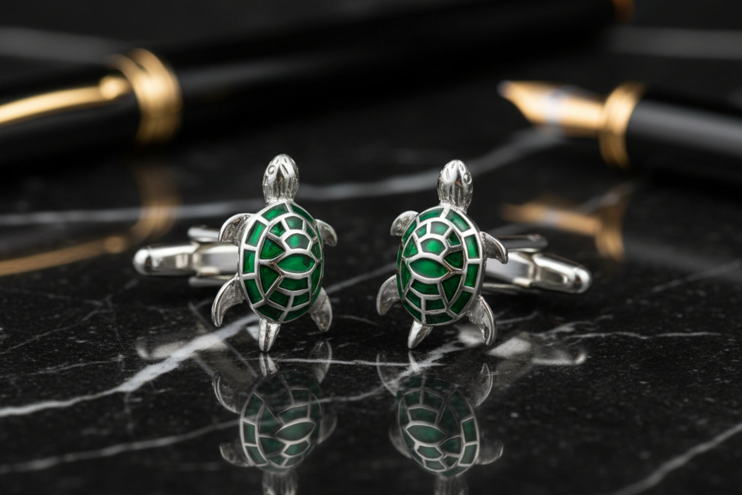 A chrome and green color turtle design pair of cuff-links.